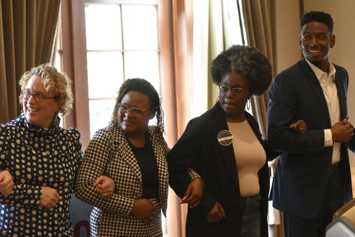 From left, Arthur Blank Foundation President and Director Fay Twersky, Georgia state Reps. Park Cannon and Jasmine Clark and Alabama state Rep. Jeremy Gray lock arms in a get-to-know-you exercise at the Future Caucus’ Future Summit South.
