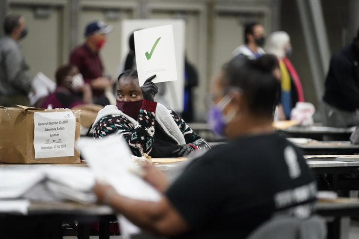 An official holds up a green check mark sign as they sort ballots during an audit at the Georgia World Congress Center on Saturday, Nov. 14, 2020, in Atlanta.