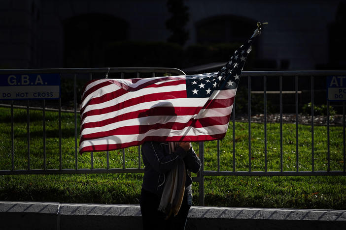 A woman holding an American flag attends a "stop the steal" rally at the Georgia State Capitol.