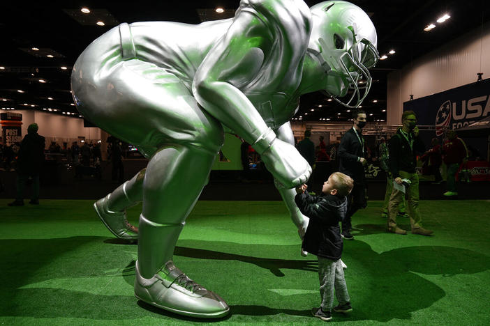 A child fist bumps a statue in Indianapolis, Saturday, Jan. 8, 2022. Alabama plays Georgia in the NCAA college football championship game on Monday.