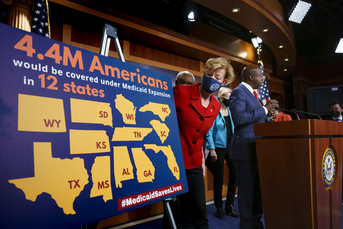 a woman looks at a chart about Medicaid expansion