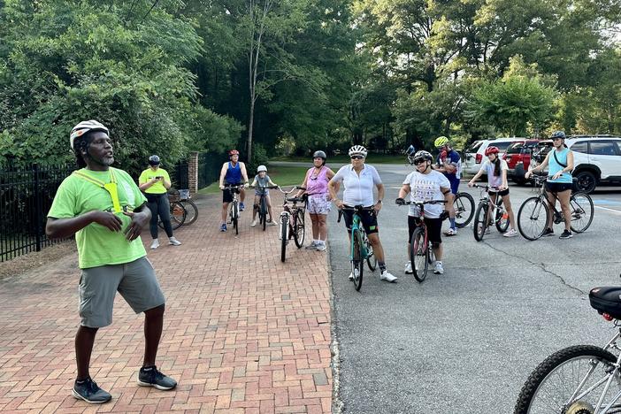 Rudy Mendes, education program coordinator for Bike Walk Macon, instructs participants on bike safety at the Macon Bike Party Rivoli Roll group ride on June 8, 2023. Josephine Bennett / GPB.