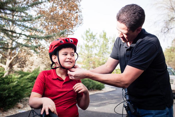 Adam Woodrum and his son, Robert, get ready for a bike ride near their home in Carson City, Nev., this month. During the summer, Robert had a bike accident that resulted in a hefty bill from the family's insurer.