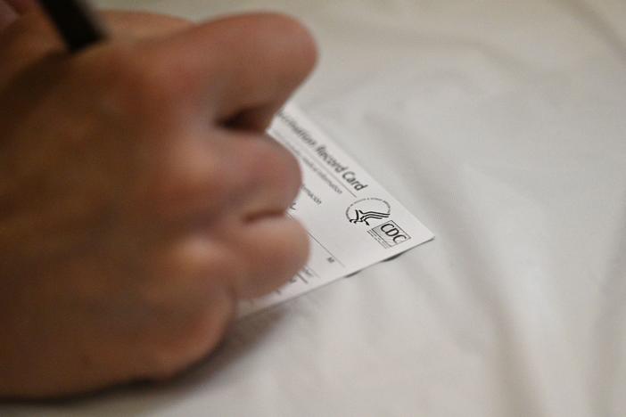 A nurse fills out a vaccine card at an L.A. Care Health Plan vaccination clinic at Los Angeles Mission College.