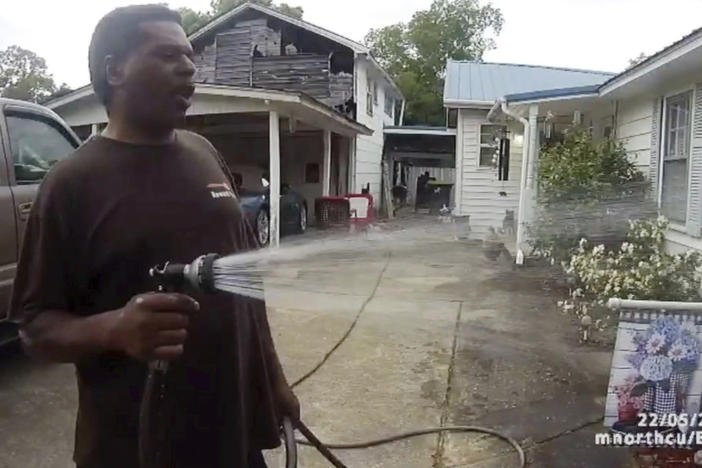 This image captured from bodycam video released by the Childersburg (Ala.) Police Department and provided by attorney Harry Daniels shows Michael Jennings, left, in custody in Childersburg, Ala., on May 22. Jennings was helping out a friend by watering flowers when officers showed up and placed him under arrest within moments.