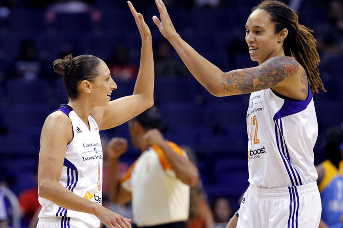 Phoenix Mercury guard Diana Taurasi, left, high-fives teammate Brittney Griner during a 2014 WNBA basketball game in Phoenix. Griner plans to return to the Mercury on a one-year contract.