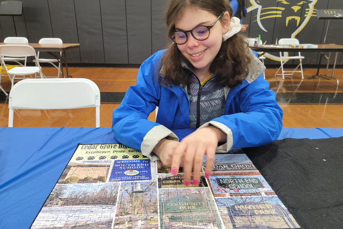 Mora Leeb places some pieces into a puzzle during a local puzzle tournament. The 15-year-old has grown up without the left side of her brain after it was removed when she was very young.