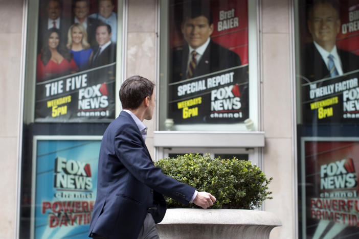 A pedestrian walks past the News Corp. headquarters building in New York displaying posters featuring Fox News Channel personalities on April 19, 2017.