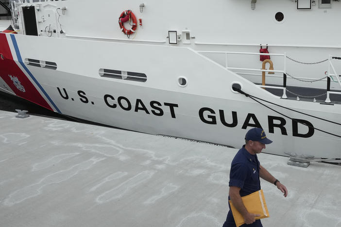 U.S. Coast Guard Cutter Warren Deyampert is docked Tuesday as a member of the Coast Guard walks past at Coast Guard Base Boston.