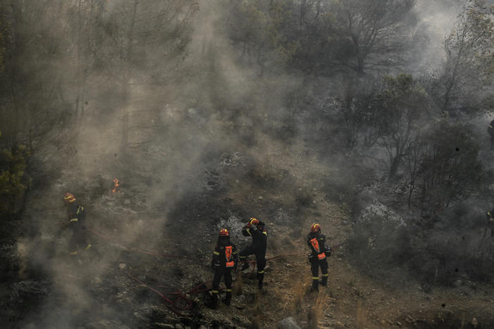 July 19, 2023: Firefighters work to extinguish a wildfire in a forest near Nea Peramos, west of Athens.