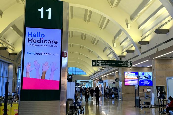 Open enrollment for Medicare begins Sunday and ads like this billboard inside California's John Wayne Airport are popping up. Marketing of Medicare plans is subject to new, stricter federal regulations this year.