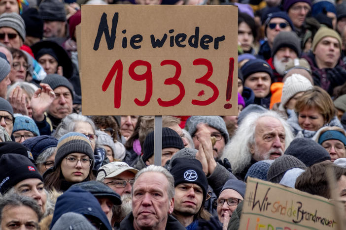 People gather as they protest against the AfD party and right-wing extremism in Frankfurt/Main, Germany, Saturday, Jan. 20, 2024. Sign reads "never again 1933".