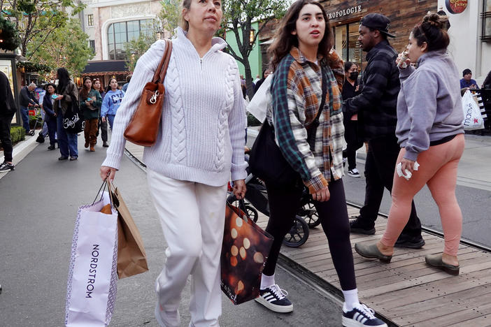 A person carries shopping bags at a shopping center on the day after Christmas on Dec. 26, 2023 in Glendale, Calif. Strong consumer spending helped drive better-than-expected economic growth in the final months of 2023.