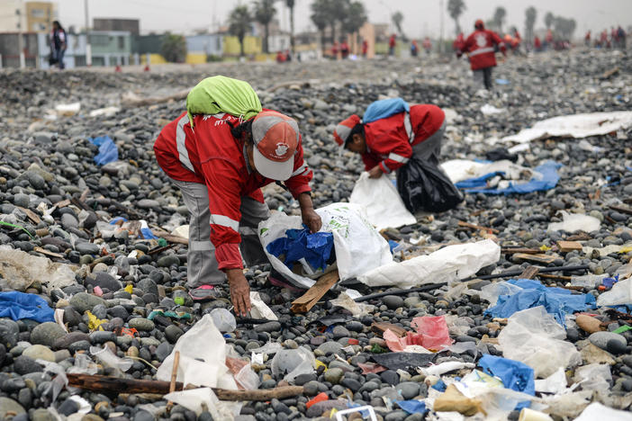 Volunteers clean up plastic waste on a beach in Peru.
