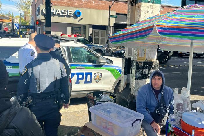 Police arrest an alleged thief, not shown, on Roosevelt Avenue in Queens, New York. The neighborhood has seen a jump in robbery over the past year. Many residents blame migrants, but this suspect was American.