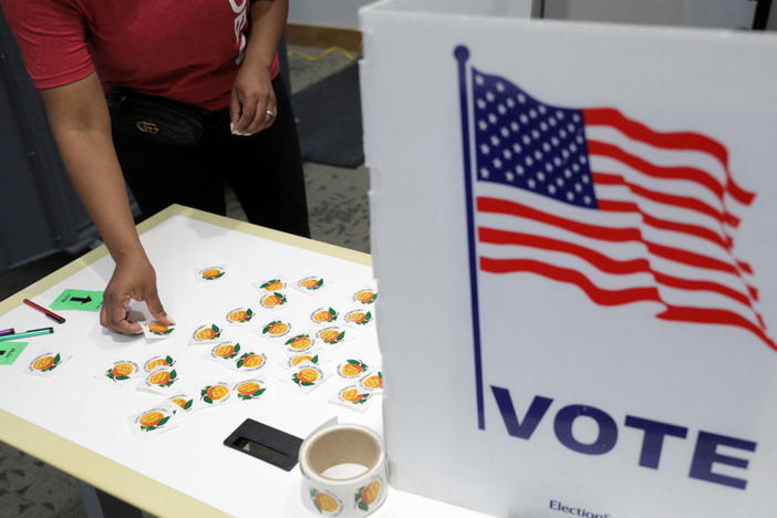 A person collects "I voted" sticker at a polling station in Fulton County during the primary election in Atlanta, Georgia, U.S. May 24, 2022. REUTERS/Dustin Chambers