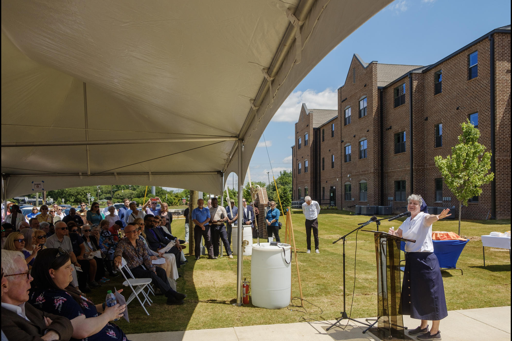 Sister Theresa Sullivan, right, speaks during the ceremony Monday marking the near completion of Macon's Central City Apartments.