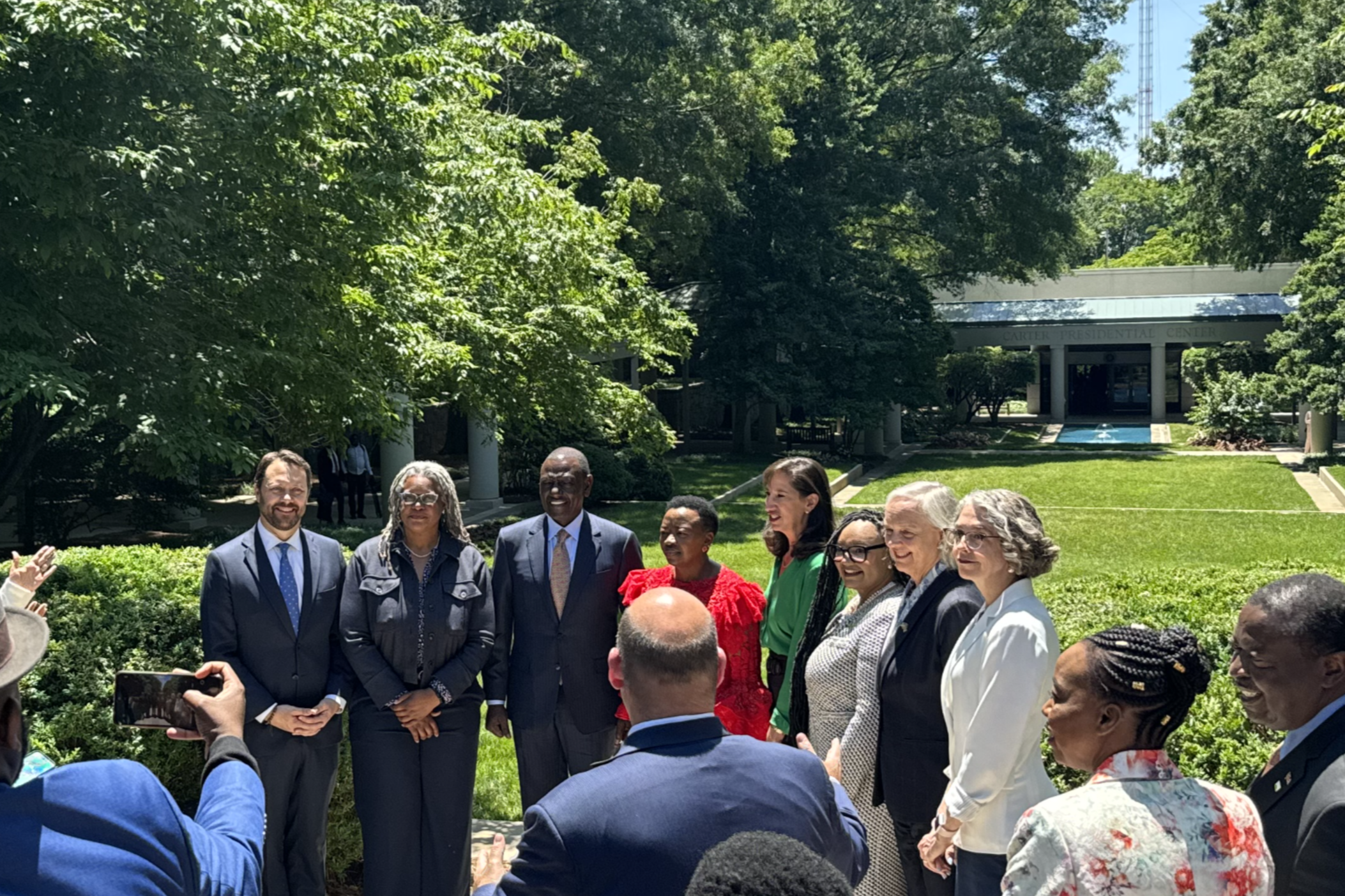 Kenya's President William Ruto (third from left) and his wife Rachel Ruto (in red) are flanked by Carter Center executives and U.S. Ambassador to Kenya Meg Whitman outside the Jimmy Carter Library and Museum during the African leader's visit to Atlanta on May 20, 2024.