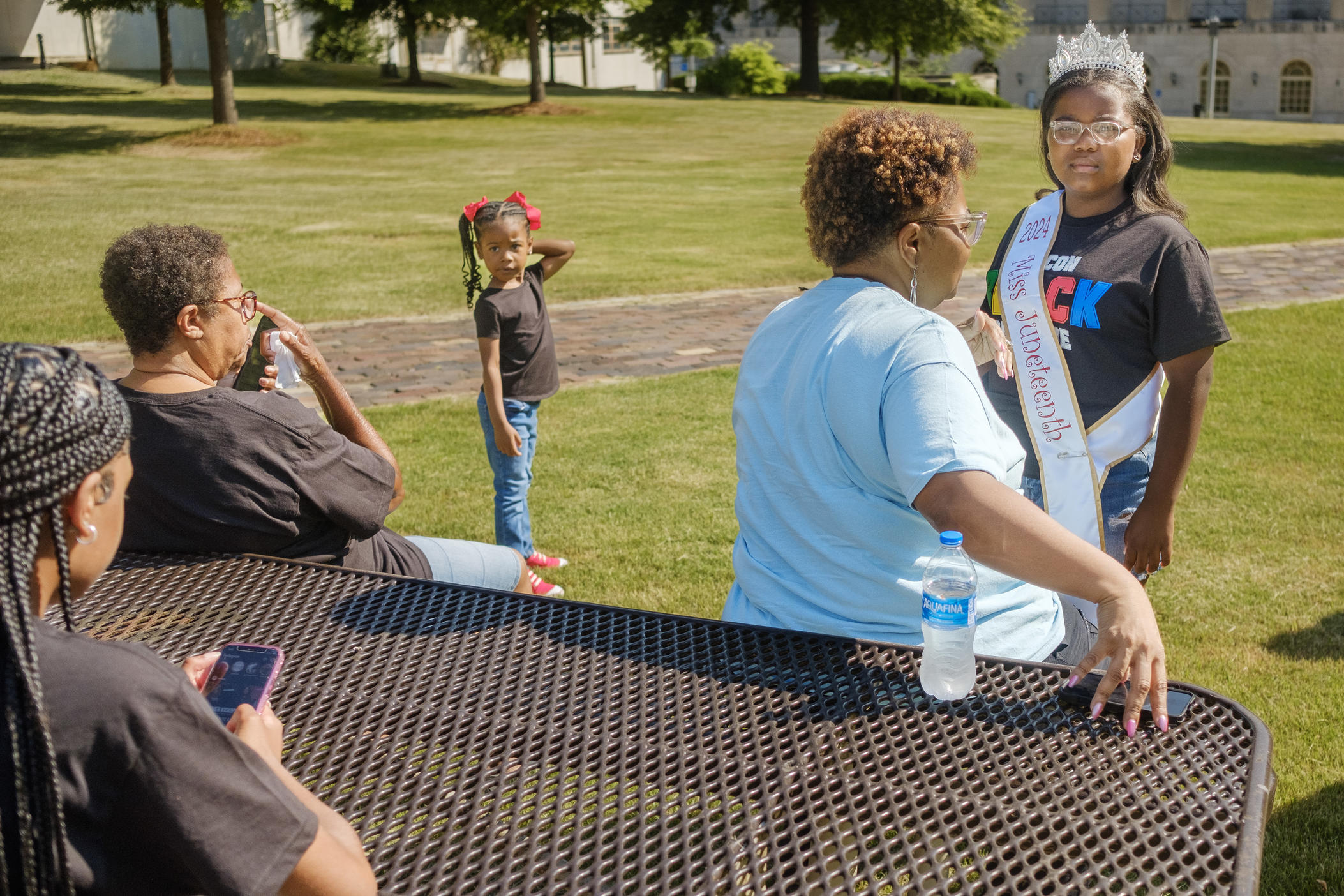 Erica Joy Scandrett, right, 11, gets a final straightening of her Miss Juneteenth sash and tiara from her mother Tiffany Scandrett before a ceremonial wreath laying as a part of Juneteenth observances in Macon on Thursday, June 13. Erica won her post in part through her speech about the role of the major theme in Macon’s Juneteenth observances this year, Black Girl Magic, in her life. 