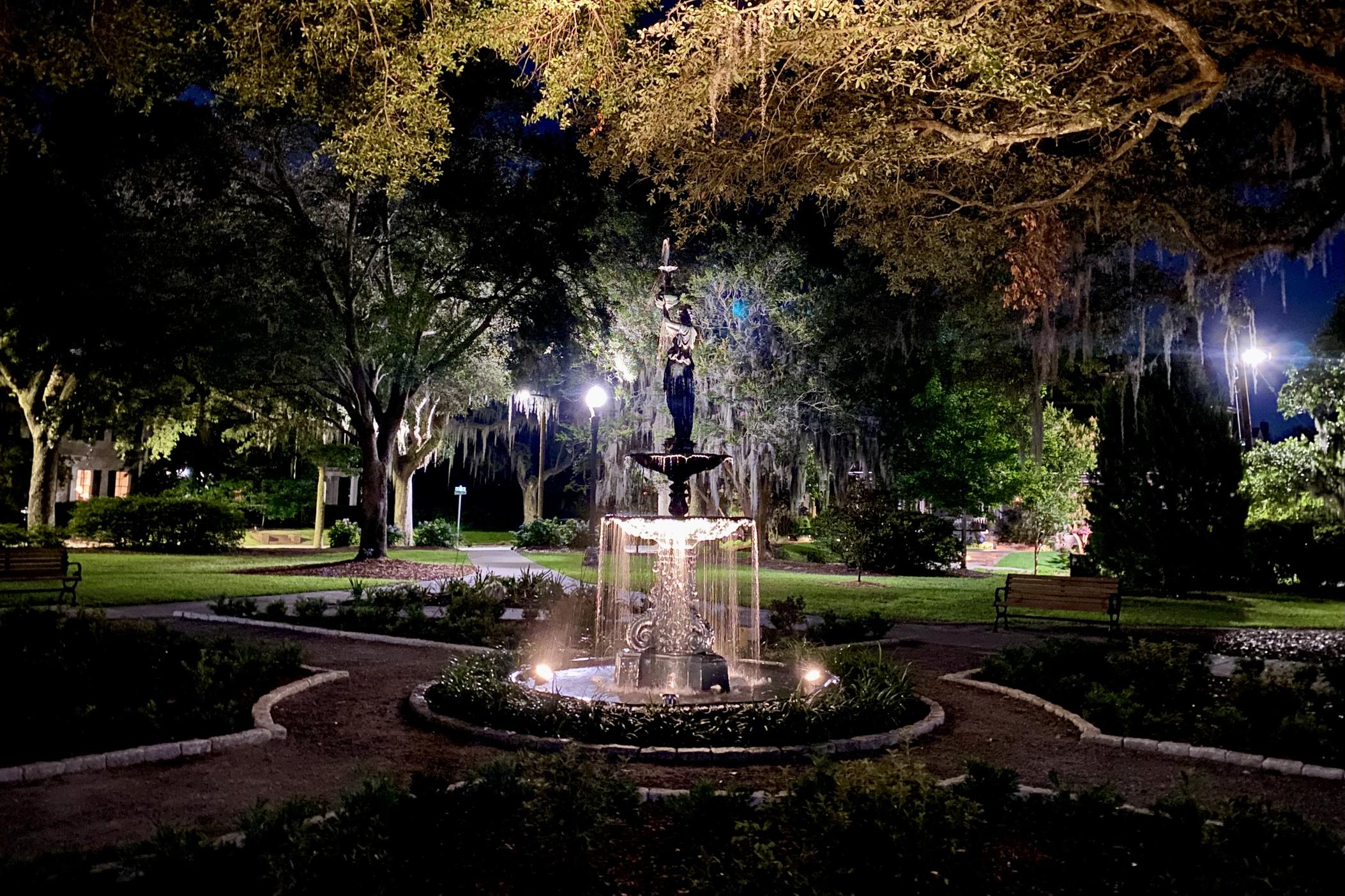 When lit up at night, “The Garden Keeper” fountain at Kavanaugh Park casts an enchanting amber glow onto the live oak tree above.