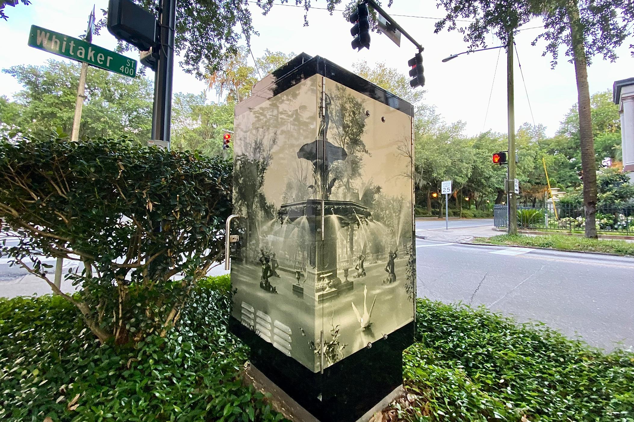An archival photo of Savannah's Forsyth Park fountain circa 1902 is displayed on a new vinyl laminate covering around a traffic light cabinet at the intersection of Whitaker Street and Gaston Street.