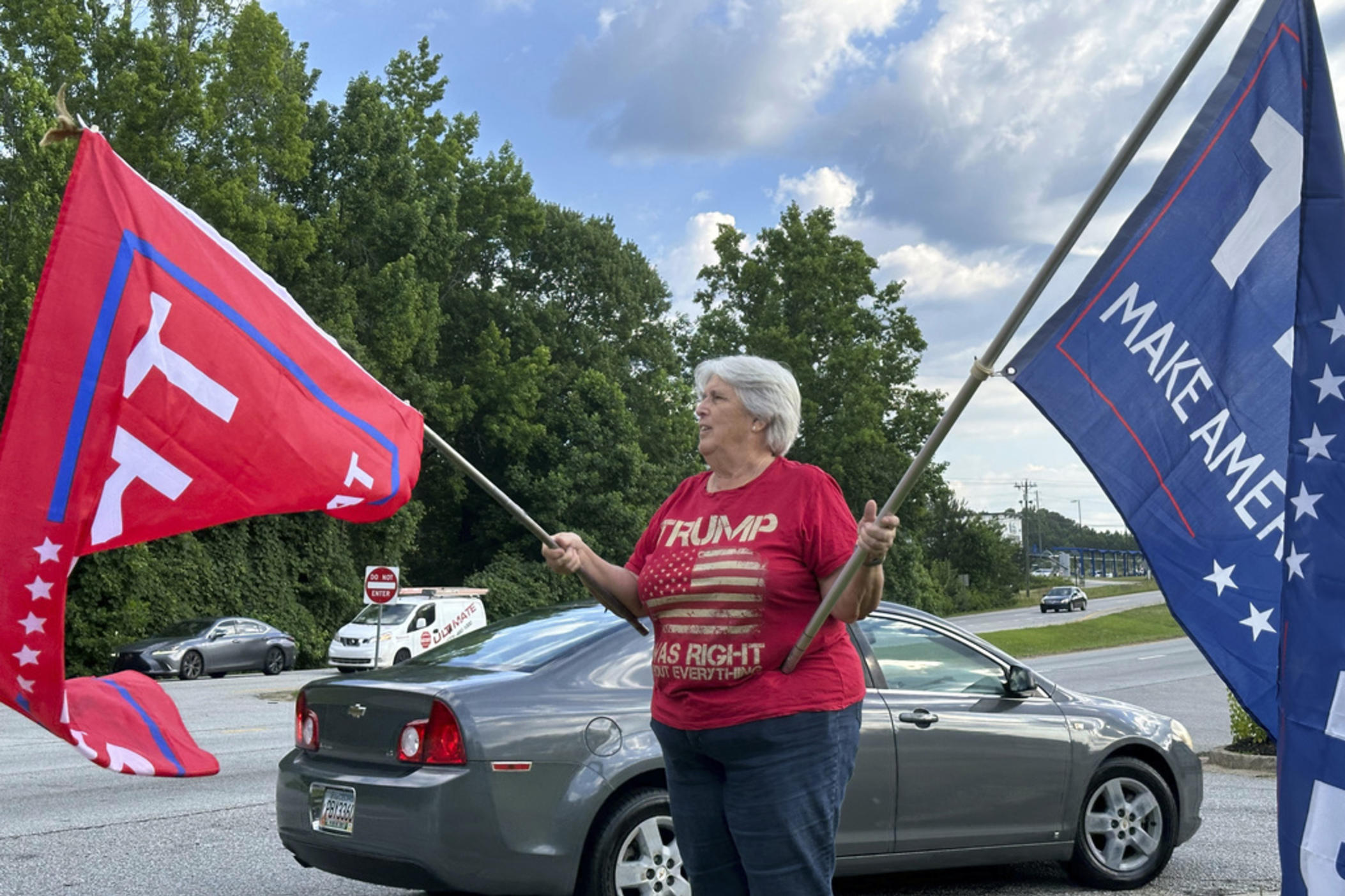 Suzanne Brown waves flags for Donald Trump before a ceremony to open his first Georgia campaign office, Thursday, June 13, 2024, in Fayetteville, Ga. Democratic President Joe Biden and former Republican President Donald Trump are working to win over Georgia voters ahead of the pair's first 2024 debate scheduled for Thursday, June 27, in Atlanta.