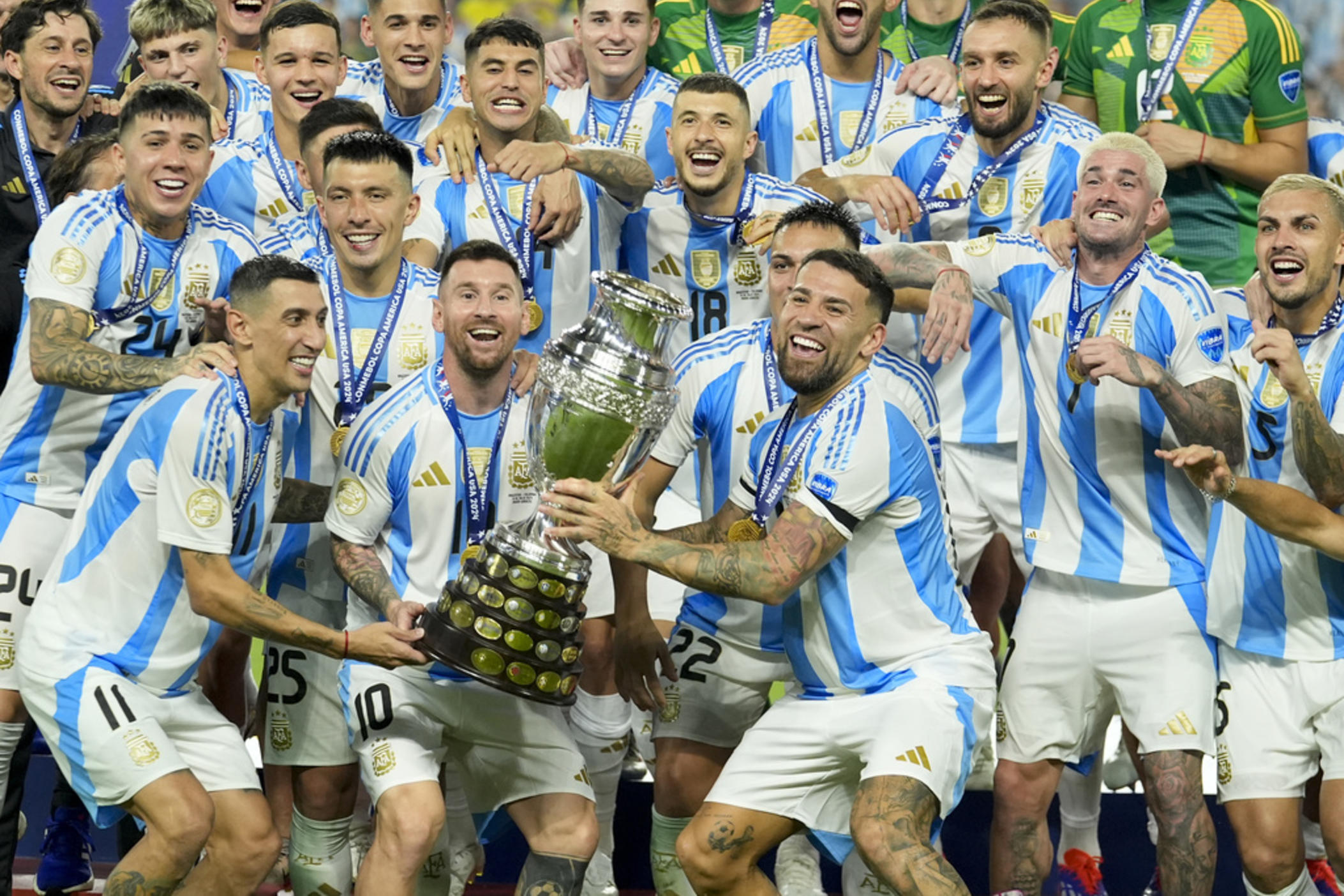 Argentina players Angel di Maria (left), Lionel Messi (second from left), and Nicolas Otamendi (third from left) celebrate with the trophy after defeating Colombia in the Copa America final soccer match in Miami Gardens, Fla., early Monday, July 15, 2024.