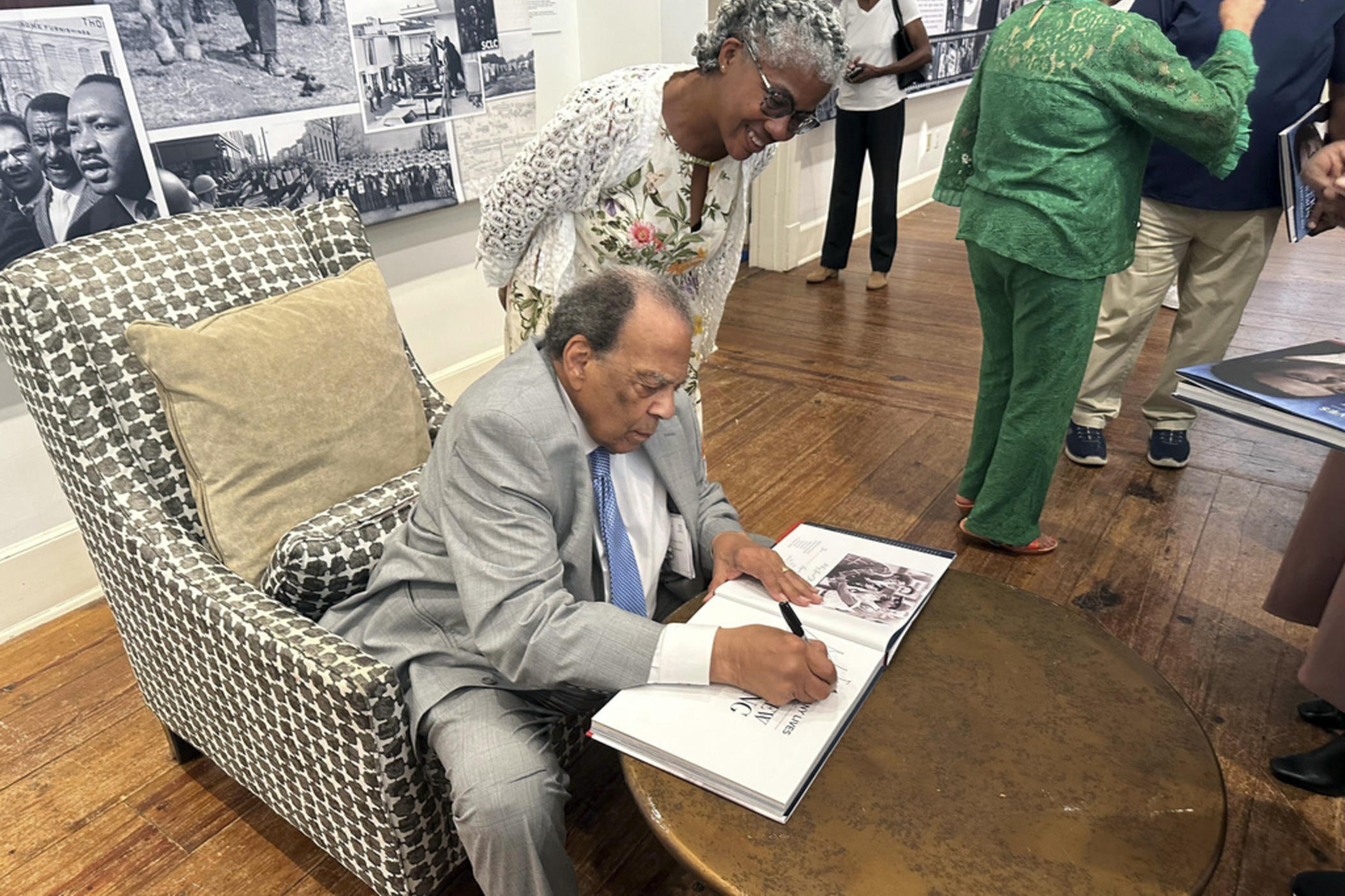 Civil rights icon Andrew Young signs a book for Sonjia Daymond at the opening of a traveling exhibit chronicling his life, Thursday, Aug. 8, 2024 in Thomasville, Ga. (AP Photo/Brendan Farrington)