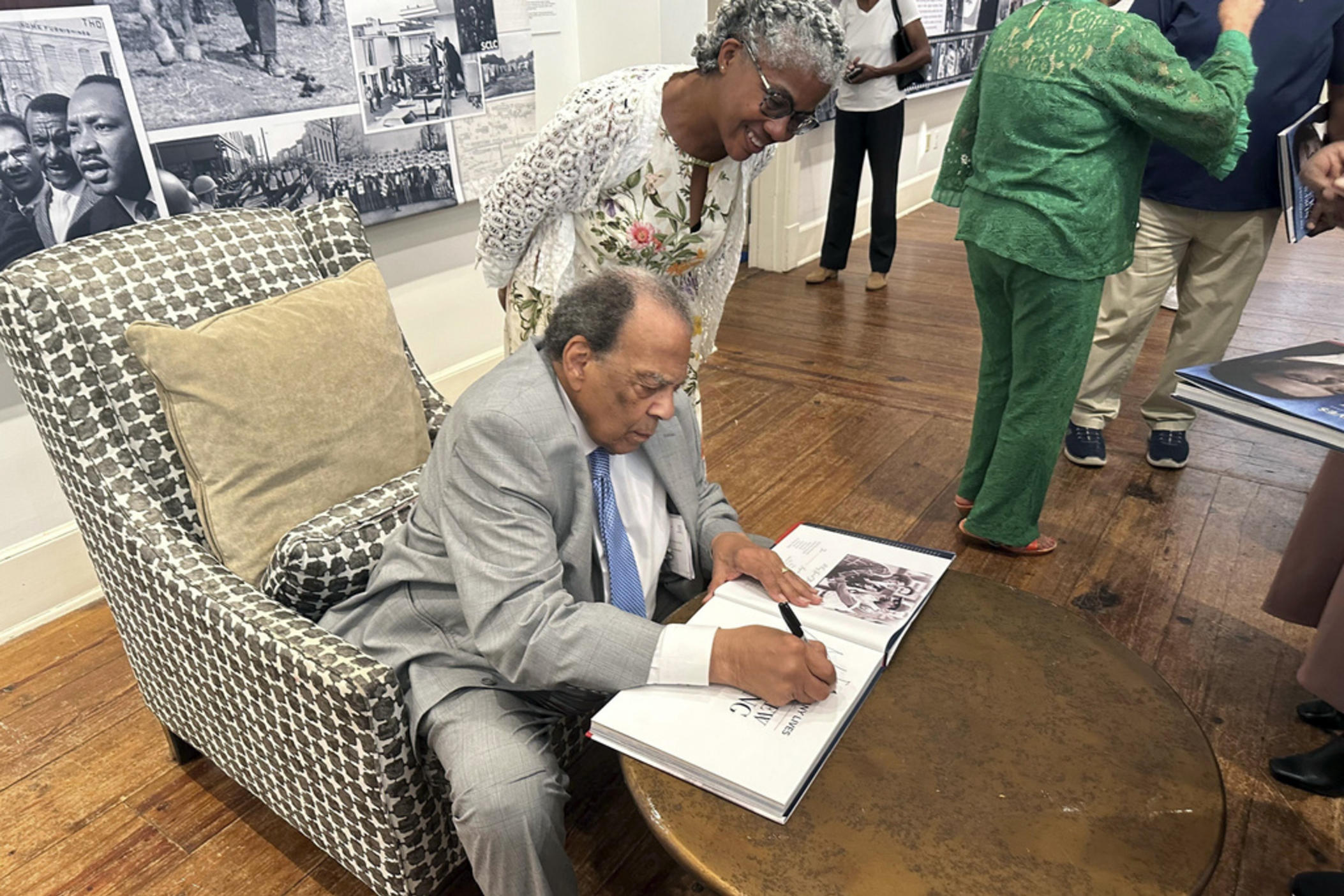 Civil rights icon Andrew Young signs a book for Sonjia Daymond at the opening of a traveling exhibit chronicling his life, Thursday, Aug. 8, 2024 in Thomasville, Ga. 