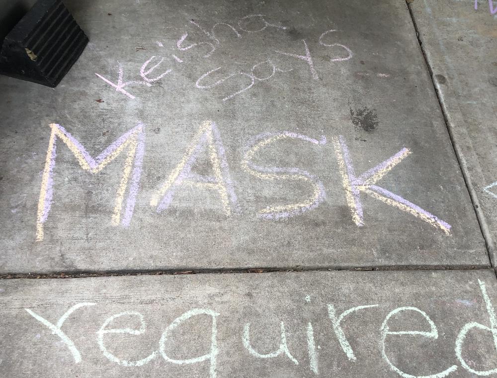 Chalk outside of an Atlanta coffee shops says masks are required by Mayor Keisha Lance Bottoms.