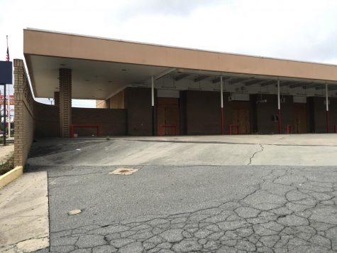 The front of the proposed liquor store would face the old bus parking spaces on the side of the building. The curved brick wall would be demolished.