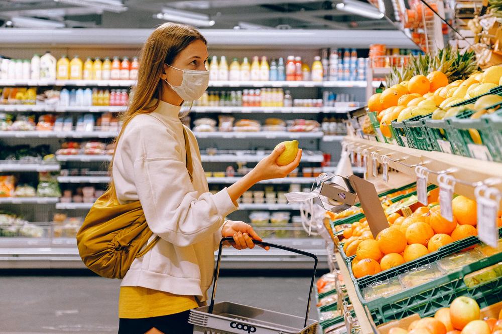 Woman grocery shopping in a mask