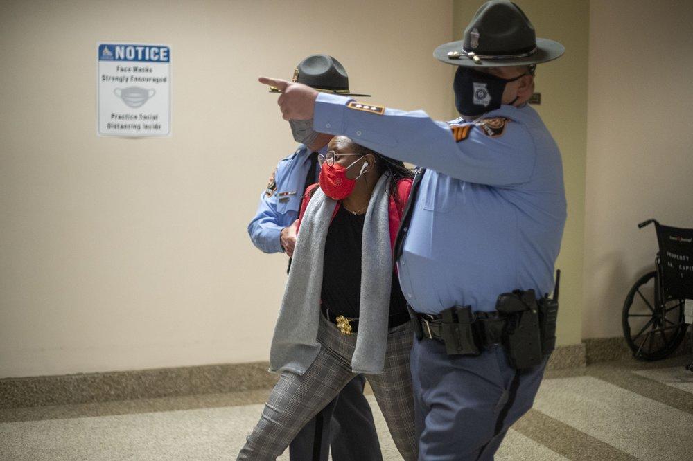 Rep. Park Cannon is escorted out of the Georgia Capitol Building by Georgia State Troopers after being asked to stop knocking on a door that lead to Gov. Brian Kemp's office while Gov. Kemp was signing SB 202 behind closed doors at the Georgia State Capitol Building in Atlanta, Thursday, March 25, 2021.