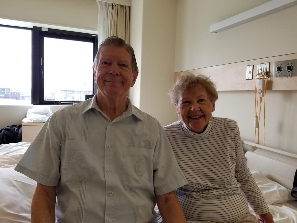 Clyde and Renee Smith sit on a bed in a Japanese hospital room in February 2020