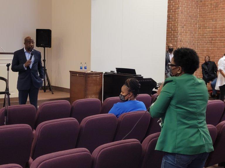Sen. Raphael Warnock answers questions about federal aid from mothers Friday at Jackson Memorial Church in Atlanta.