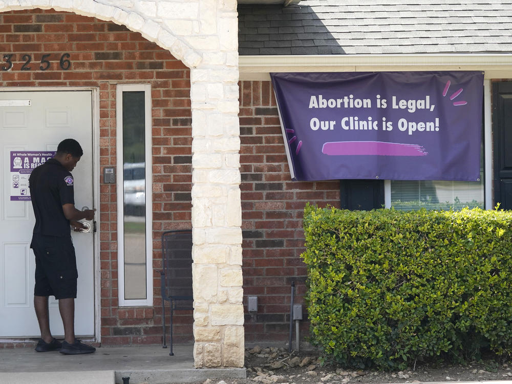 In this Sept. 1, 2021 file photo, a security guard opens the door to the Whole Women's Health Clinic in Fort Worth, Texas.