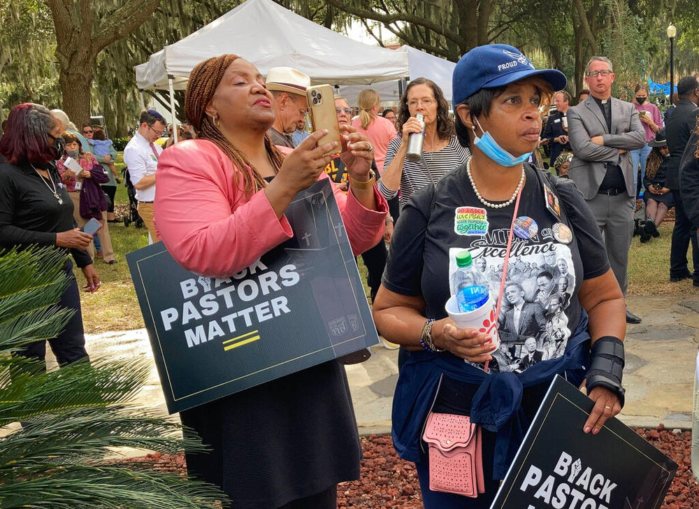 Protesters stand outside the Glynn County Courthouse on Thursday, Nov. 18, 2021 in Brunswick, Ga., during the trial of Greg McMichael and his son, Travis McMichael, and a neighbor, William "Roddie" Bryan. The three are charged with the February 2020 slaying of 25-year-old Ahmaud Arbery.