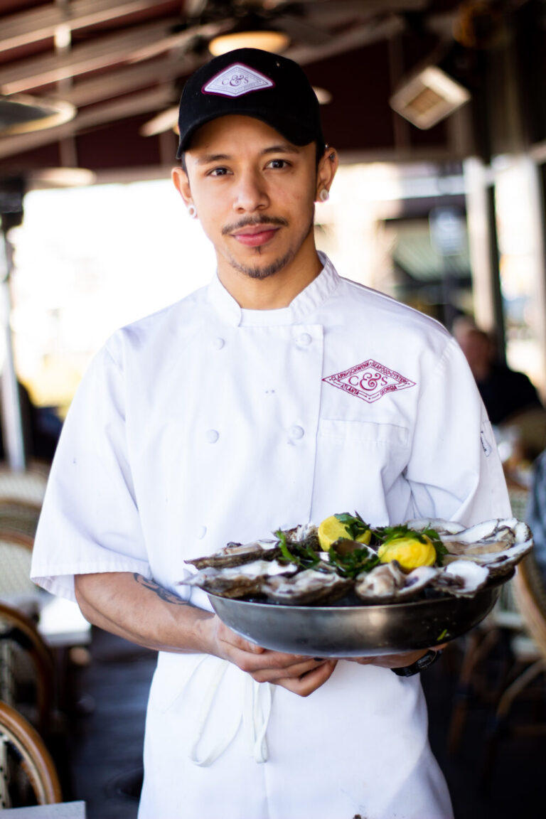Giovanni Ramirez, a sous chef at C&S Seafood & Oyster Bar, holds a plate of oysters that he has prepared.
