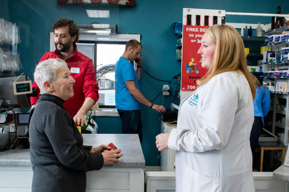 Suzanne Davenport (right) speaks with customer Toni Bunch (left) as she purchases vitamins at Southern Drug Company in Blue Ridge, Ga. on March 7. 