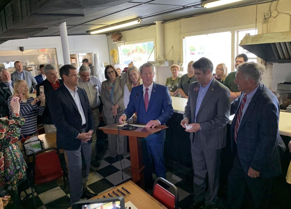 Gov. Brian Kemp signed a tax cut into law inside the cramped quarters of the White Diamond Grill in Bonaire, which is his GOP challenger’s favorite local restaurant. 