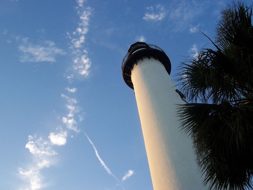 The St. Simons Island Lighthouse is shown under a blue sky.