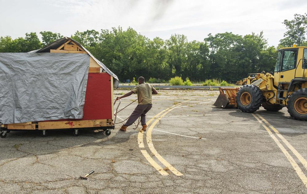 A man tries to pull his home out of the way of a heavy equipment-aided sweep of a homeless encampment in Macon in June. 