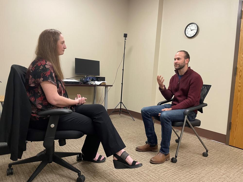 Two clinical counseling psychology students at Brenau University conduct a mock therapy session while seated in an office room.