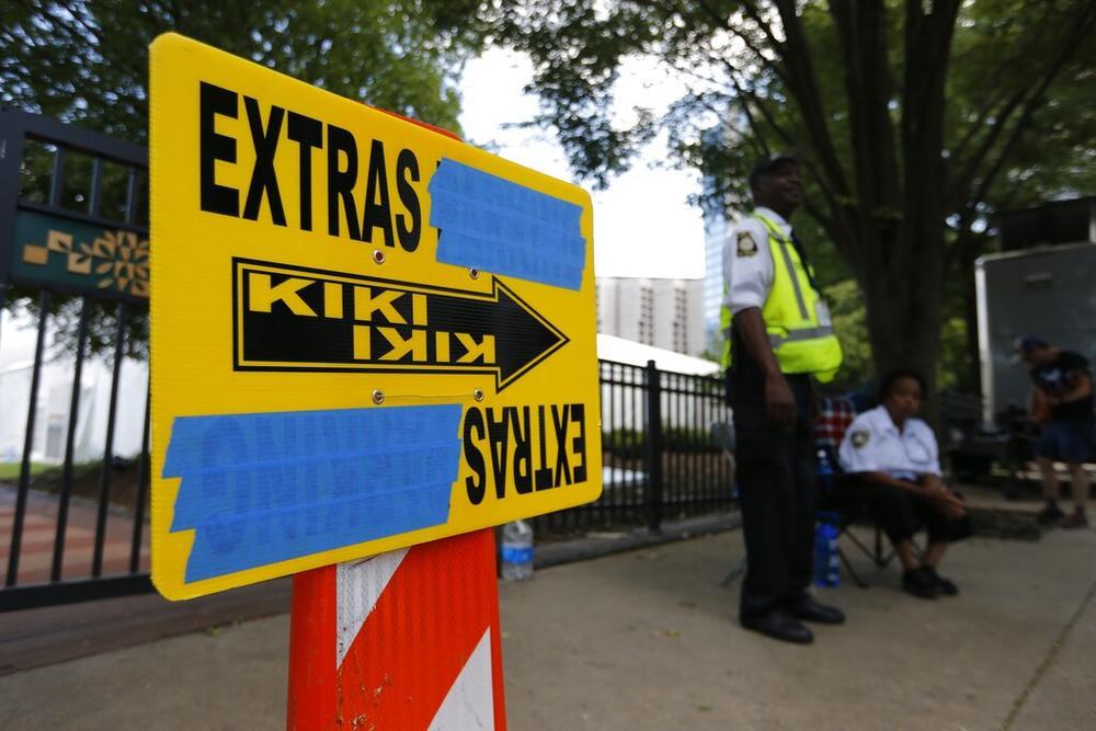 In this Thursday, July 25, 2019 photo, security guards are posted near an entrance to Centennial Olympic Park in downtown Atlanta where a sign for movie extras is set up for Clint Eastwood's film currently titled "Richard Jewell." AP Photo/Andrea Smith