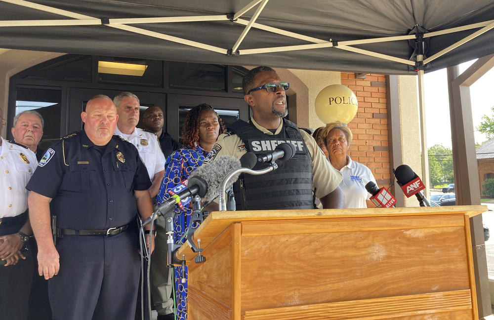 Henry County Sheriff Reginald Scandrett speaks on Sunday, July 16, 2022, in Hampton, Ga, while flanked by other police and local officials. Scandrett announced that officers shot and killed Andre Longmore on Sunday, a day after officials say Longmore shot and killed four Hampton residents.