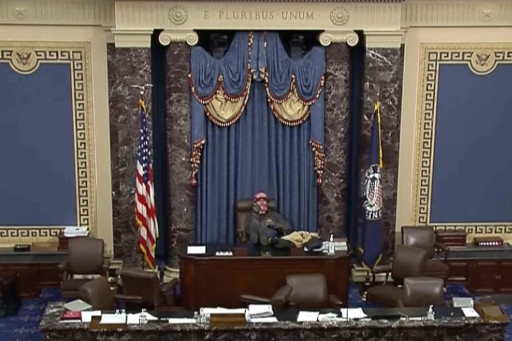 This image from U.S. Senate video, introduced at the trial of Bruno Joseph Cua, shows Cua sitting with his feet up in the Senate chamber on Jan. 6, 2021, during the riot at the U.S. Capitol. Cua, who stormed the U.S. Capitol, assaulted a police officer and sat in a Senate floor chair reserved for the vice president was sentenced on Wednesday, July 26, 2023, to one year in prison.