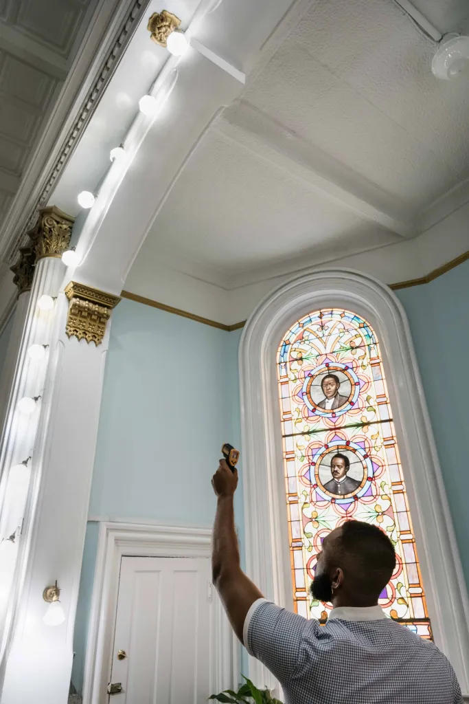Anthony Kinslow uses an infrared thermometer to measure the heat put out by an LED light bulb at First African Baptist Church. 