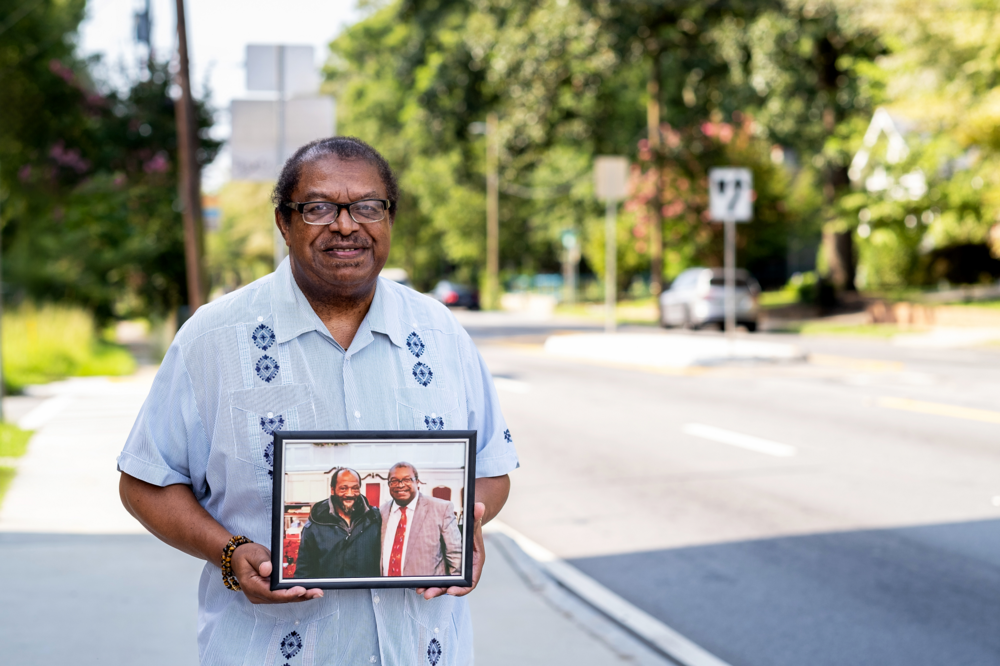 The Rev. Tim McDonald holding a photo of Emanuel Biggs, who was killed on Atlanta's Moreland Avenue in October 2022.