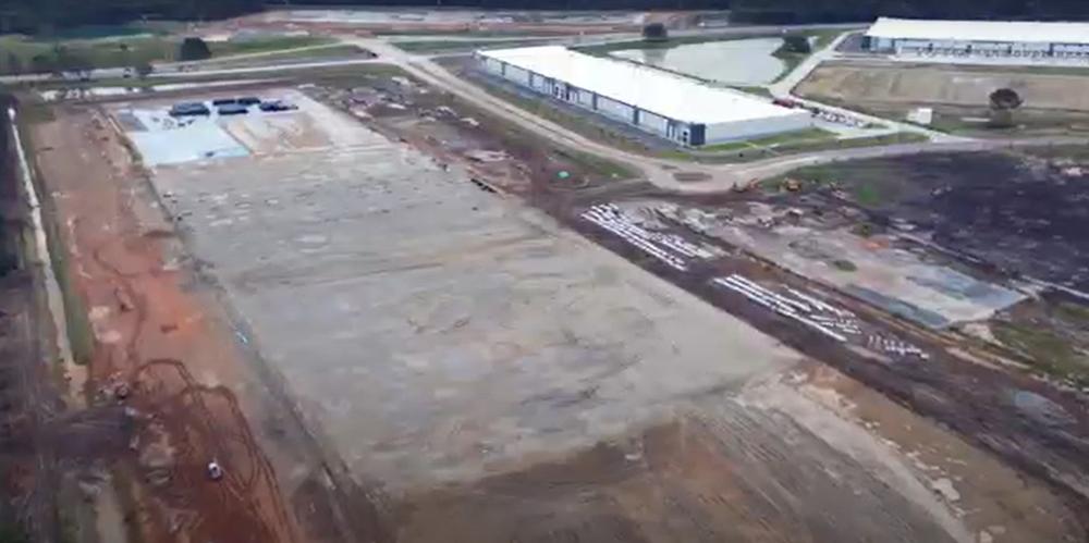 An aerial image of a warehouse under construction is shown.