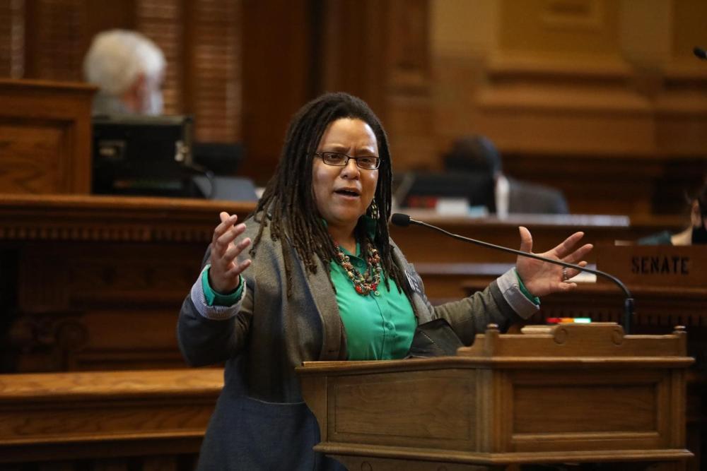 Stone Mountain State Senator Kim Jackson is shown speaking from behind a lectern in the legislative chamber.